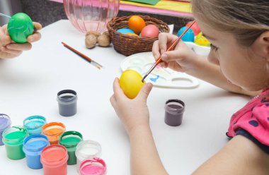 Paskalya için hazırlanıyorum. Masadaki çocuklar yumurta yiyorlar. Yan görünüm