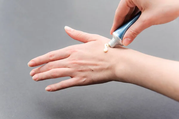 Cura della pelle per le mani femminili. Applicare la crema sulla mano sinistra — Foto Stock