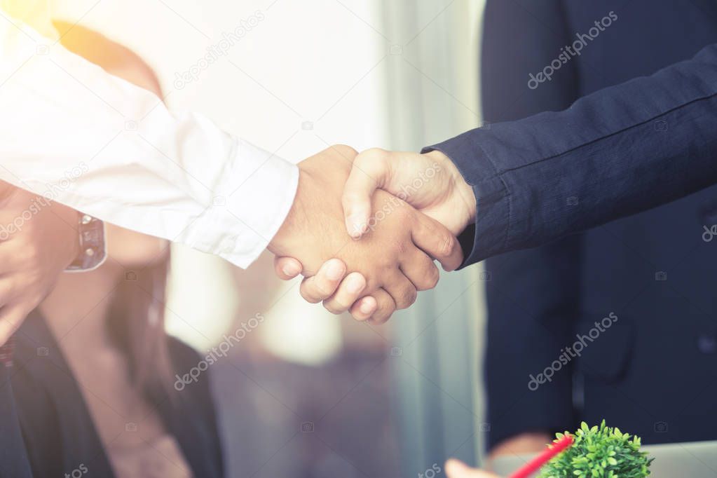 close up of businessmen handshaking after good deal, business concept