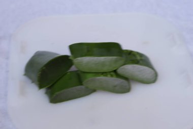 Aloe vera yaprak ve hamuru parçaları beyaz bir arkaplanda izole edilmiş.