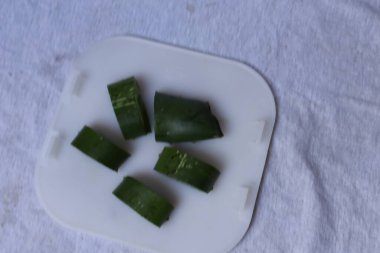 Aloe vera yaprak ve hamuru parçaları beyaz bir arkaplanda izole edilmiş.