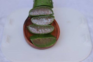 Aloe vera yaprak ve hamuru parçaları beyaz bir arkaplanda izole edilmiş.