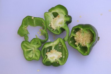 Beyaz arkaplanda izole edilmiş yeşil dolma biber ya da kapsiyum dilimi