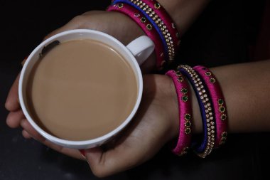 Süslü bir fincanda sıcak Masala Çayı ve beyaz arka planda çay tabağı.