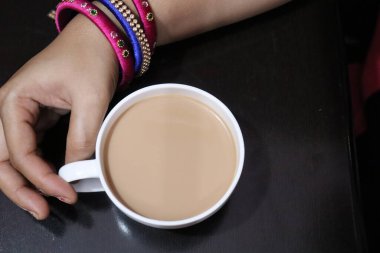 Süslü bir fincanda sıcak Masala Çayı ve beyaz arka planda çay tabağı.