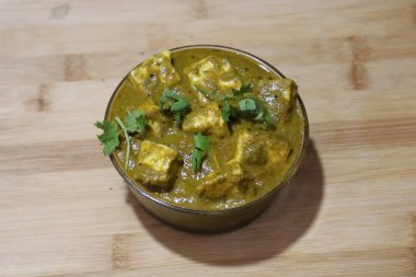 Malai ya da achari Paneer soslu, kırmızı et suyu ve yeşil kapsicum ile yapılır. Bir kasede servis edilir.