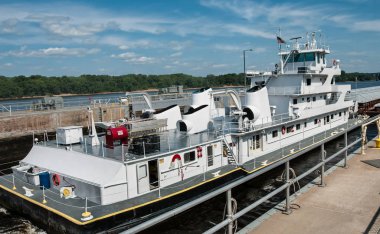 Barge Boat :  A commercial river boat pushes freight barges through one of the locks on the Mississippi River.