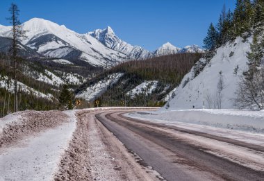 Scenic Winter Drive in Montana:  A snowy mountain road curves through a portion of Glacier National Park that remains open all year.