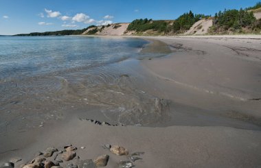 Sandy Beach in Newfoundland:  Gentle waves from the Atlantic Ocean meet the flow of a small stream at Sandy Cove Beach on the eastern shore of Newfoundland.