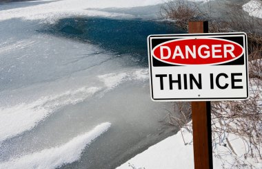 Thin Ice Warning Sign:  A sign warns of danger as ice thaws on a pond in southern Wisconsin.