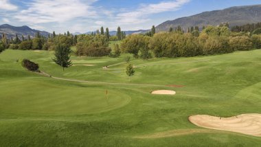 Dağ Golf Sahası: Yuvarlanan yeşil tepeler ve dağlar Britanya Kolombiya 'sında güneşli bir günde golf için cazip bir ortam yarattı.