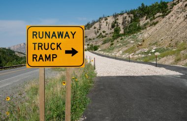 Runaway Truck Ramp Sign:  Truck drivers with failing brakes are offered an emergency escape route along a highway in the mountains of northeast Wyoming. clipart