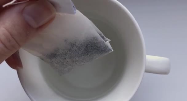 Le thé emballé est brassé dans une tasse. Un sachet de thé est descendu dans une tasse. Délicieuse tisane chaude est brassée 