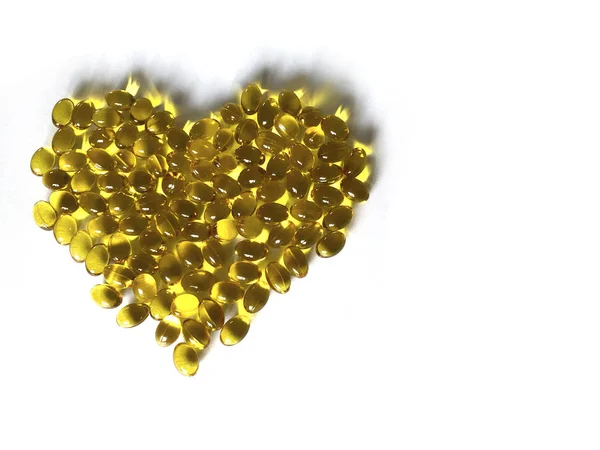 Kalp şeklindeki sarı vitaminler. D3 vitamini. Beyaz arkaplanda izole et