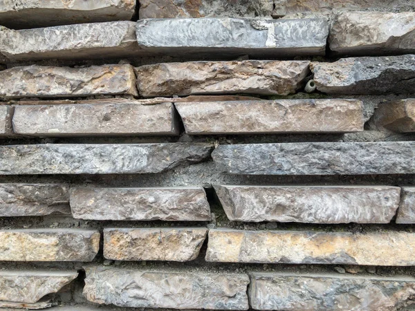 The surface of a stone wall. Masonry walls of old stone blocks. Background texture of a stone wall.