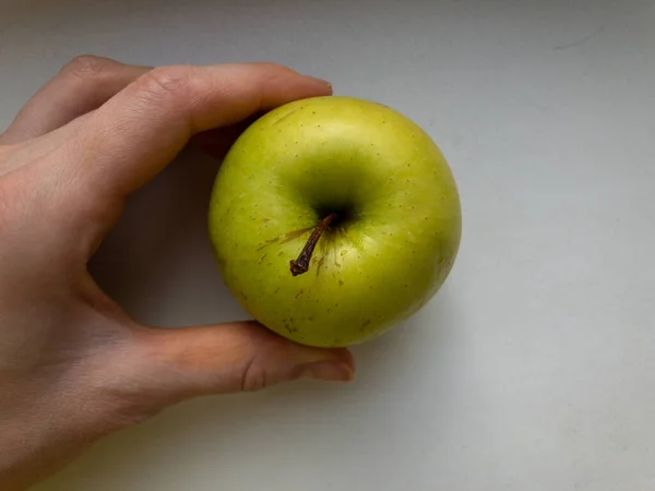 Ein grüner Apfel in der Hand. Der Blick von oben. — Stockfoto