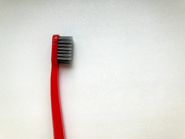 Uma escova de dentes vermelha em um fundo branco — Fotografia de Stock