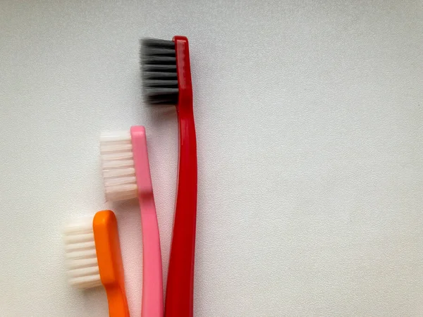 Three multi-colored toothbrushes on a white background — Stock Photo, Image