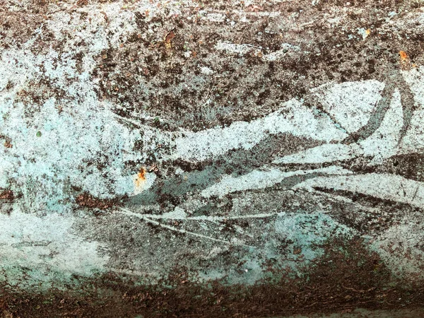 Soyut yüzey çizimi. Renkli duvar tasarımı. Eski asfaltta kurumuş, çatlamış, pürüzlü bir boya parçası. Soyut bir şekilde duvardaki duvar yazısını boyayarak..