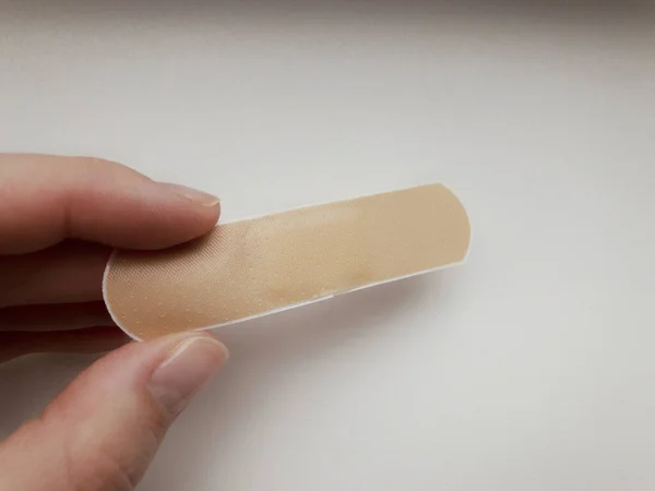 adhesive plaster in hand on a white background