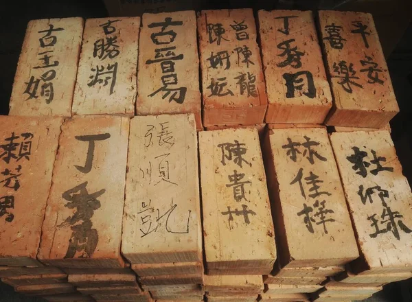 Garnerade röda tegelstenar med kinesiska skriftliga tecken — Stockfoto