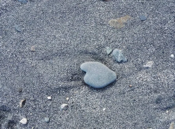 Pedra forma coração natural na areia — Fotografia de Stock