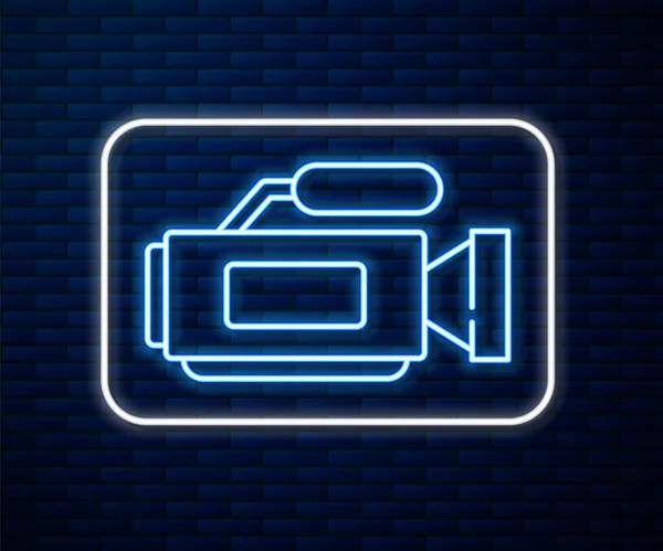 Icono de la cámara de cine en línea de neón brillante aislado en el fondo de la pared de ladrillo. Videocámara. Signo de película. Proyector de cine. Ilustración vectorial — Vector de stock