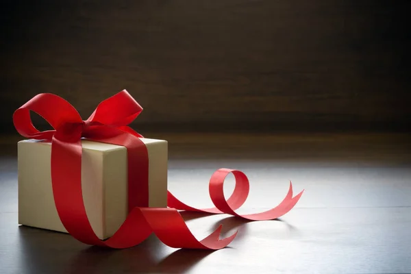Белая Подарочная Коробка Привязанная Красной Лентой Деревянному Полу — стоковое фото