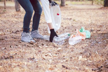 Volunteer woman collecting PET plastic bottle garbage in park for recycle. Volunteer and Save Environmental concept.