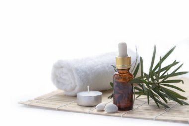 Bitkilerle ve beyaz arka planda mumlarla gerekli yağ.