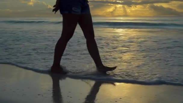 夕暮れ時に白い砂浜を歩く少女 — ストック動画