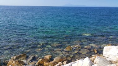 Su, gökyüzü, doğa... Yaz kumsalındaki mavi su.