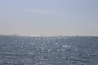 Güneşin denizdeki yansıması, uzaktaki tekneler