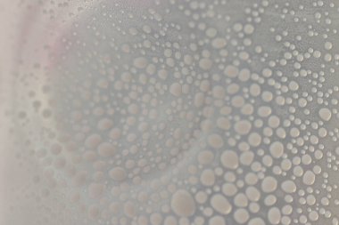 Şeffaf bir yüzeyde süt damlaları, yüzeyde damla dokuları