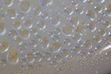 Su şeffaf plastik bir yüzeye düşer, suyun makro görüntüsü