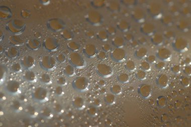 Su şeffaf plastik bir yüzeye düşer, suyun makro görüntüsü