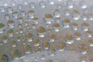 Su şeffaf plastik bir yüzeye düşer, suyun makro görüntüsü