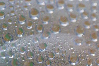 Su şeffaf plastik bir yüzeye düşer, suyun makro görüntüsü