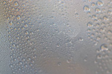 Su şeffaf plastik bir yüzeye düşer, suyun makro görüntüsü