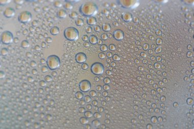 Su şeffaf plastik bir yüzeye düşer, suyun makro görüntüsü