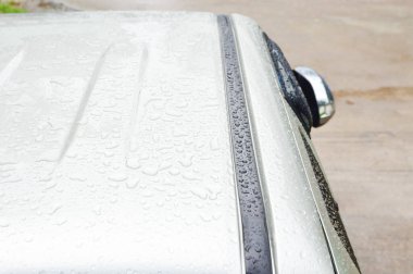 Altın arabanın çatısına düşen yağmur damlası, odaklan