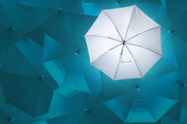 Ters dönmüş gri şemsiye gökyüzü mavisi şemsiyelerden farklıdır, farklı konseptler olmak, iş konsepti, başarısızlık ya da hata, iflas, başarısız olan bir kişi, yukarıdan bakın..