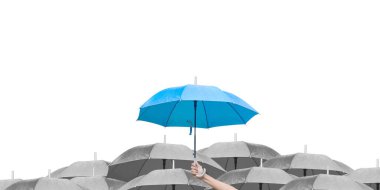 Beyaz arka planda siyah şemsiyeler üzerine mavi şemsiye. İş dünyasına liderlik etmenin farkı, yağmurda elinde mavi şemsiye tutan bir adamın elidir. yan görünüm.