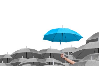 Beyaz arka planda siyah şemsiyeler üzerine mavi şemsiye. İş dünyasına liderlik etmenin farkı, yağmurda elinde mavi şemsiye tutan bir adamın elidir. yan görünüm.