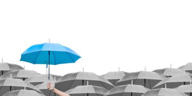 Beyaz arka planda siyah şemsiyeler üzerine mavi şemsiye. İş dünyasına liderlik etmenin farkı, yağmurda elinde mavi şemsiye tutan bir adamın elidir. yan görünüm.