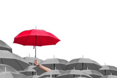 İş dünyasındaki liderliğe adım atmanın farkı. Kırmızı şemsiyeler arasında kırmızı şemsiye. Yağmurda birçok şemsiye üzerinde kırmızı bir şemsiye tutan bir adam eli. yan görünüm.
