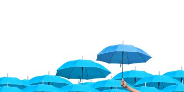 İş dünyasındaki liderliğe adım atmanın farkı. Açık mavi şemsiyeler arasında mavi şemsiye. Beyaz arka planda birçok şemsiye üzerinde mavi bir şemsiye tutan bir adam eli. yan görünüm.