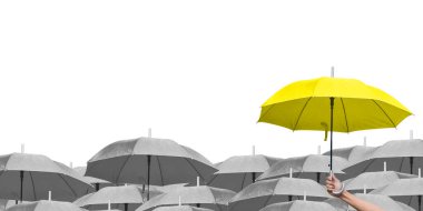 Beyaz arka planda siyah şemsiyeler üzerine mavi şemsiye. İş dünyasına liderlik etmenin farkı, yağmurda elinde mavi şemsiye tutan bir adamın elidir. yan görünüm.