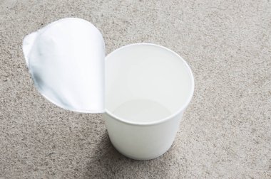Beton zeminde çatalla beyaz kağıt bardağı açtım. Ürün için beyaz bardak. Odaklan. ışık ve gölge
