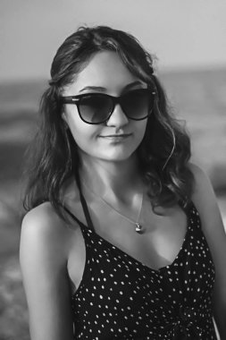 a girl walking at the beach black and white at the beach